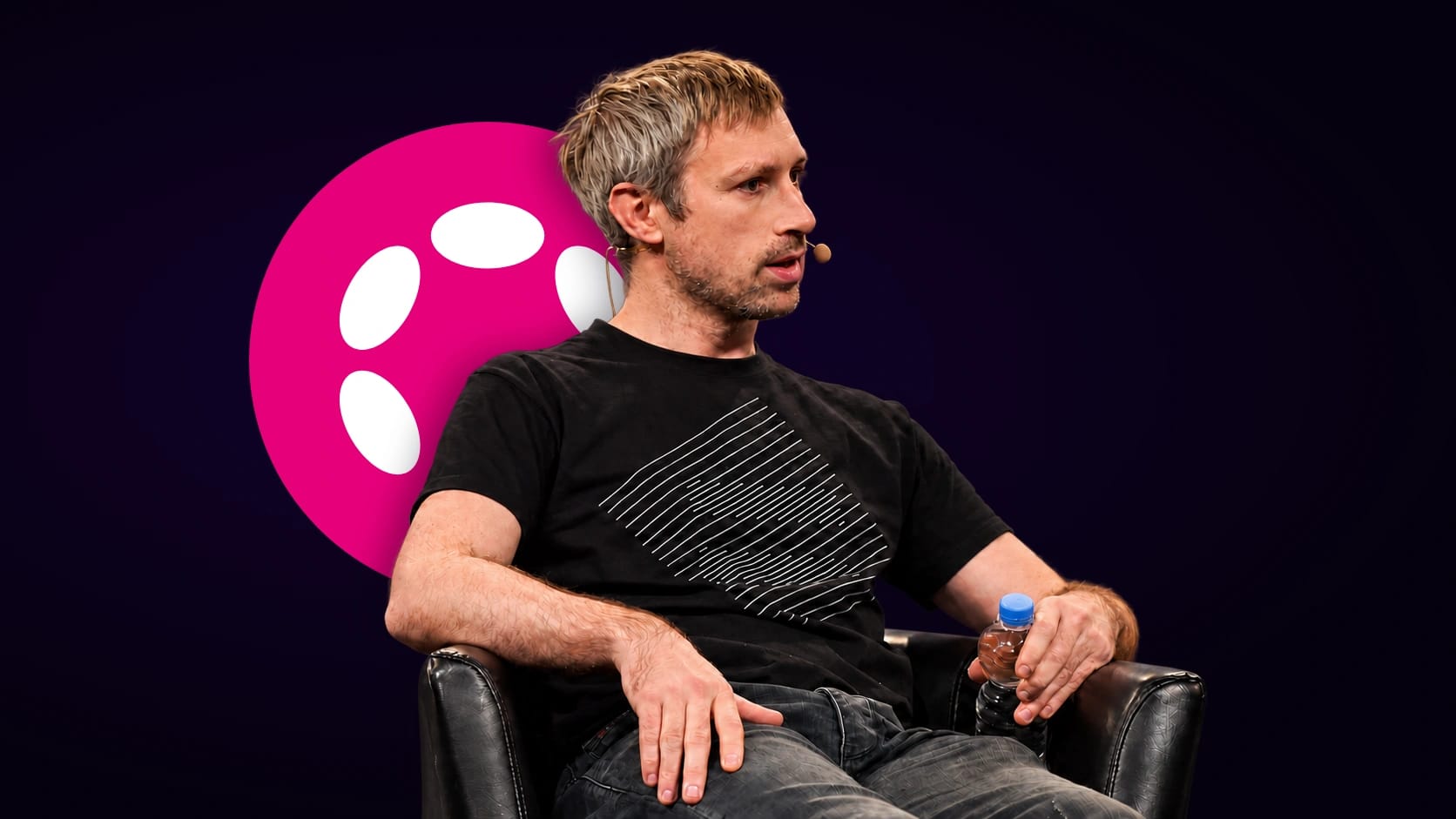 Gavin Wood ante el logo circular de Polkadot sobre fondo oscuro