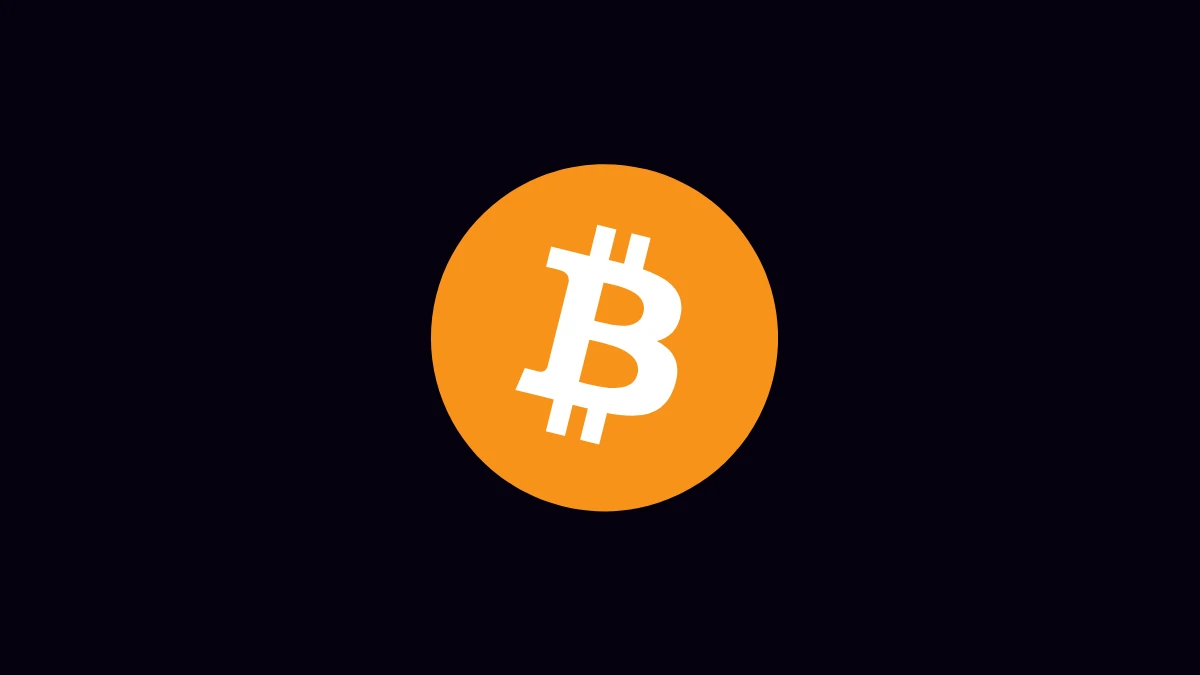 White Bitcoin logo inside its orange circle on a dark background