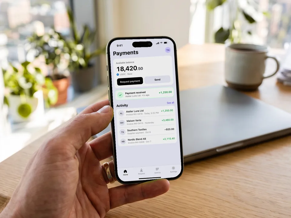 Hand holding a phone showing a 1,250 USDC payment received, a blockchain MVP pilot
