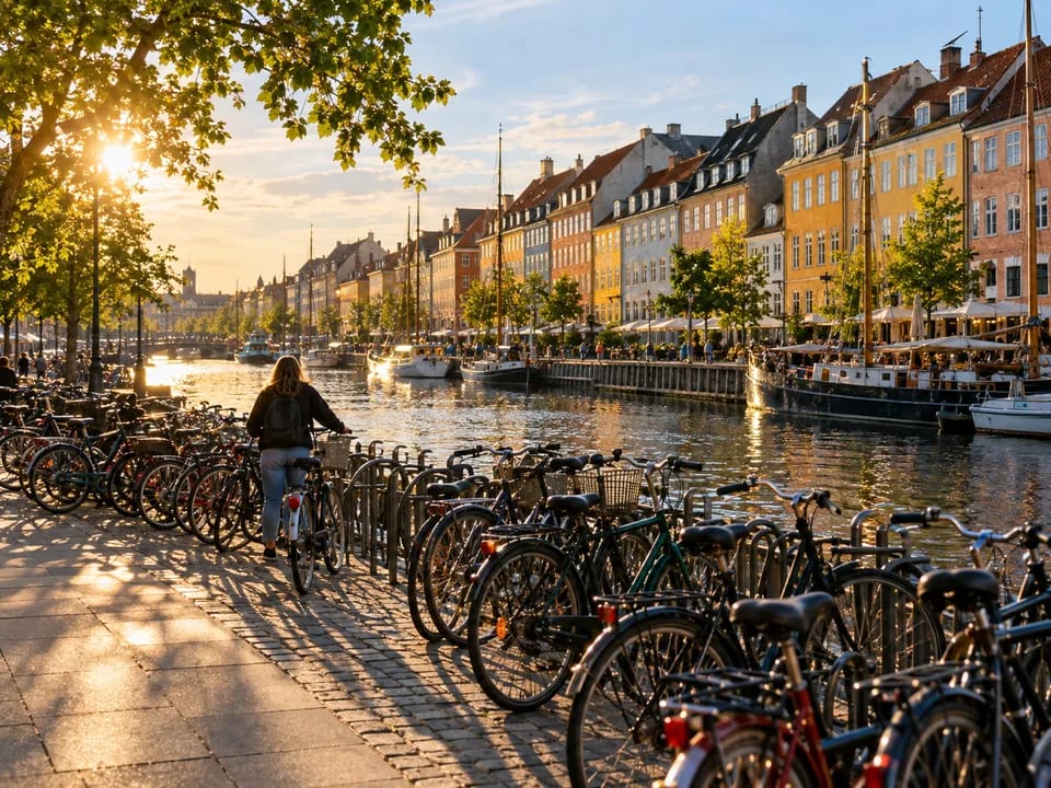 Rows of bicycles parked beside a Copenhagen canal with a cyclist seen from behind, bicycles and frame numbers with blockchain in Denmark