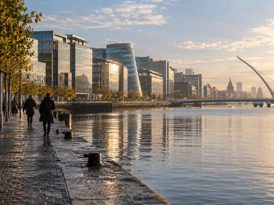 Edificios de oficinas junto al río Liffey en los Docklands de Dublín a primera hora con peatones de espaldas, participaciones de fondos con blockchain en Irlanda