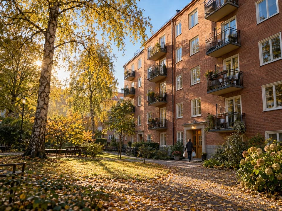 Brick apartment building with balconies in a Stockholm neighbourhood in autumn, bostadsrätt register with blockchain in Sweden