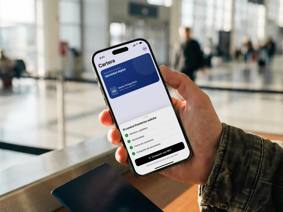 Viajero con su cartera de identidad digital en el móvil en el control fronterizo de un aeropuerto