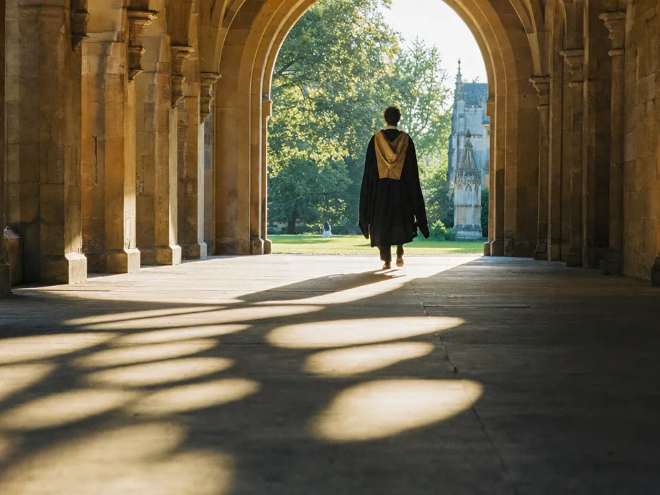 A person in a graduation gown leaving a university cloister, academic degrees as NFT