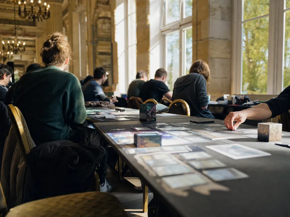 Players at a collectible card game tournament, in-game content reserved through token gating