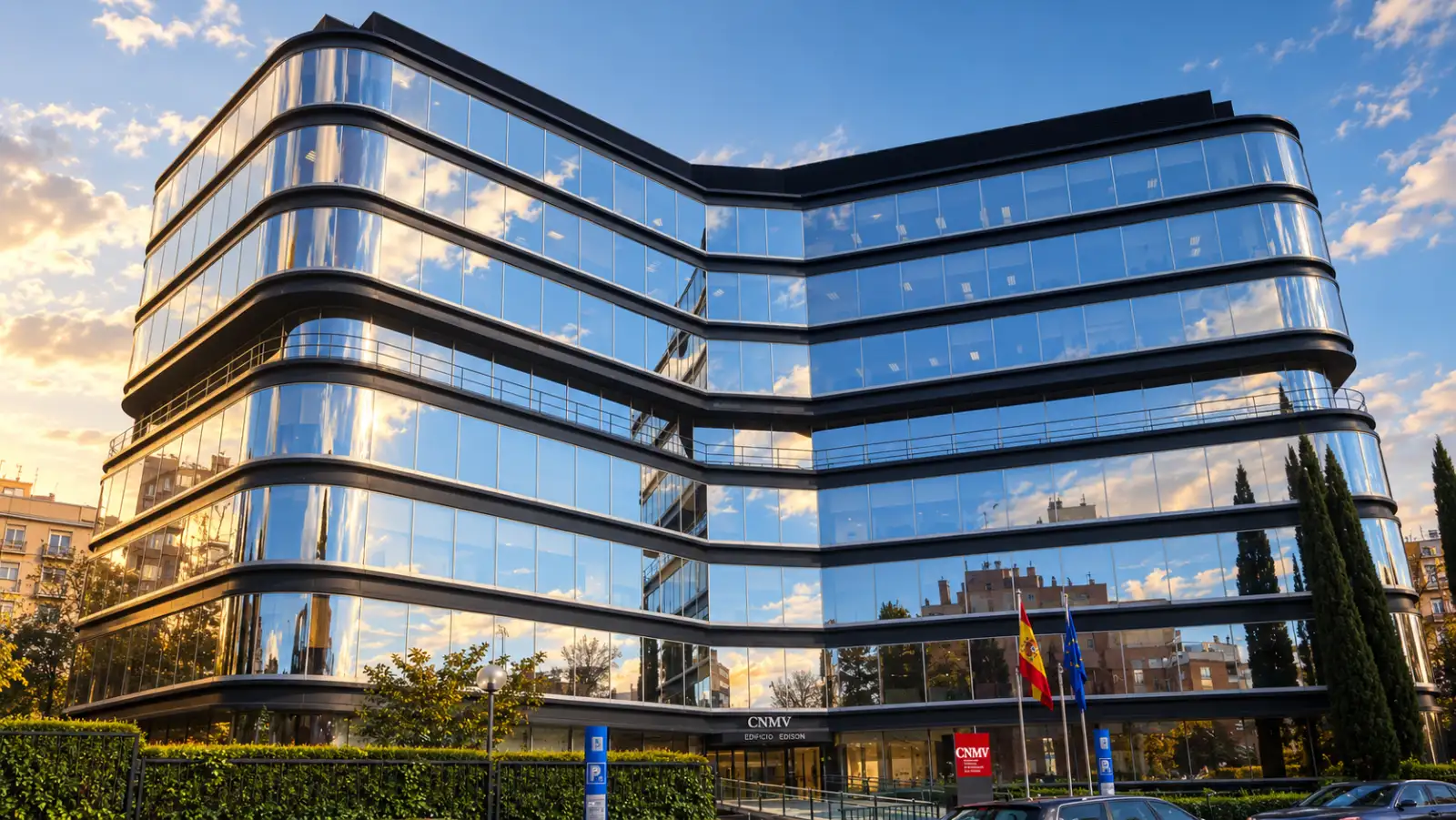 Glass facade of the CNMV’s Edison building in Madrid, with the Spanish and European Union flags