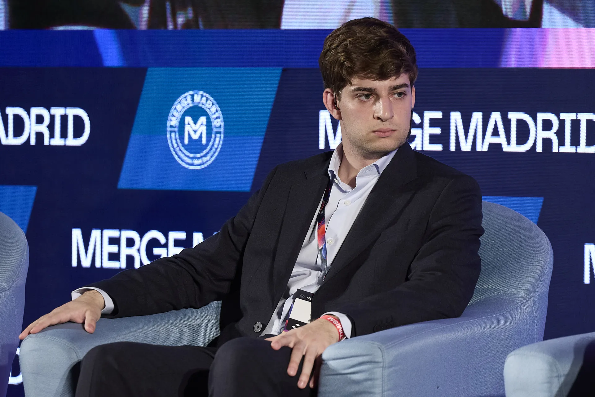 Pablo Gómez, CEO of Metlabs, seated on the MERGE Stage with the MERGE Madrid logo behind him